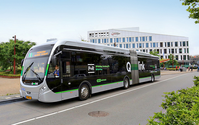 Ein silberner Bus von Qbuzz fährt durch eine Stadt