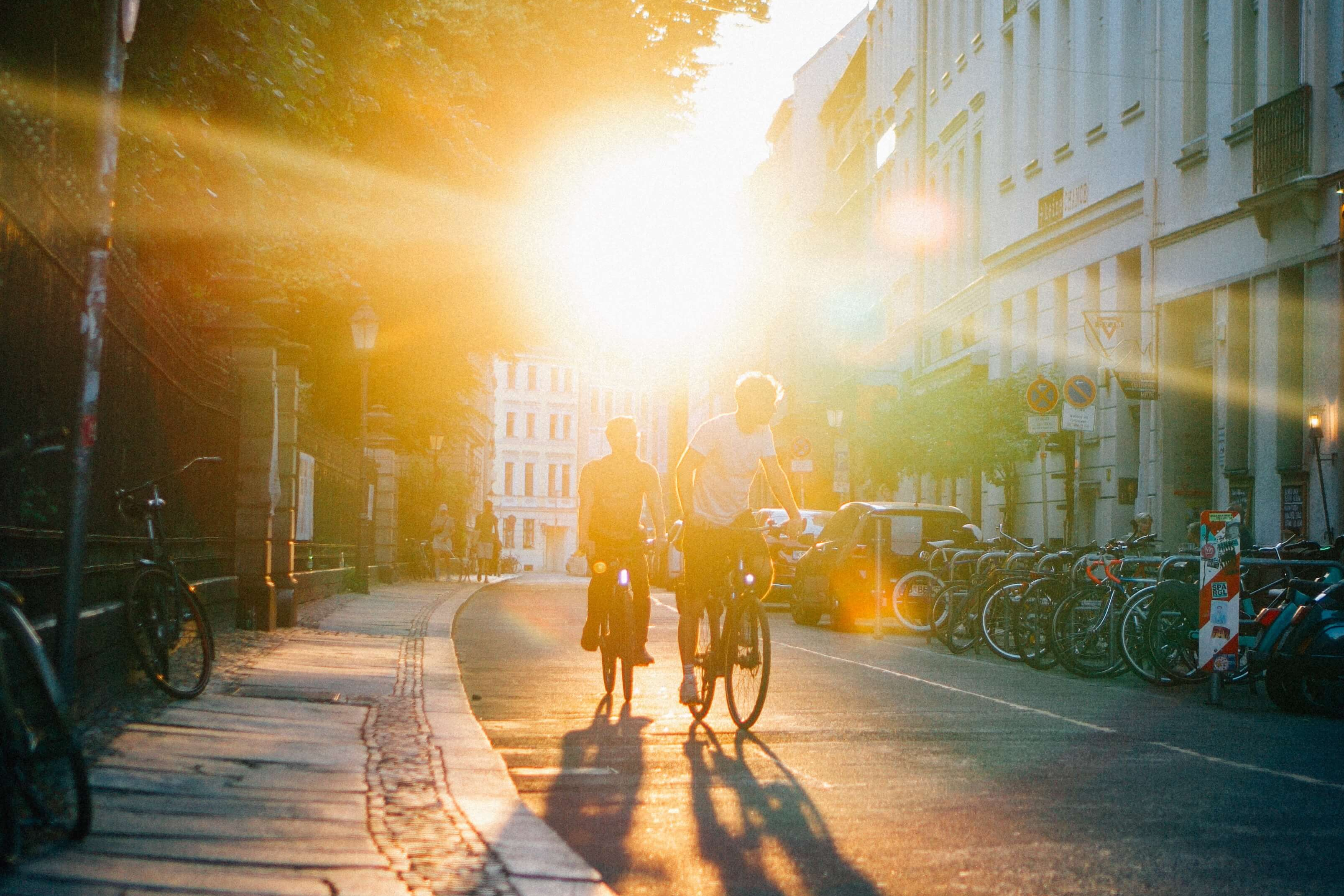 Dos ciclistas recorren la carretera al atardecer