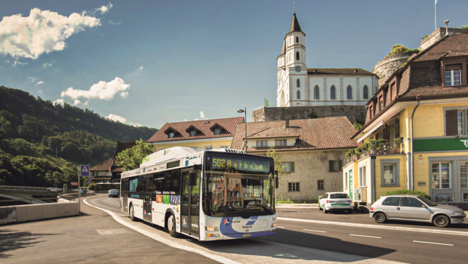 Bus auf der Straße vor alten Gemäuern mit blauem Himmel