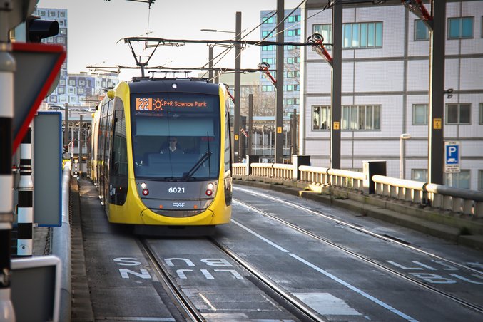 Un tranvía amarillo y negro de la provincia de Utrecht se detiene en una estación.