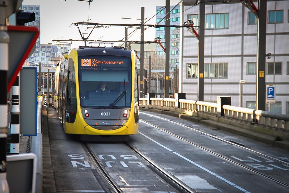 Un tranvía amarillo y negro de la provincia de Utrecht se detiene en una estación.