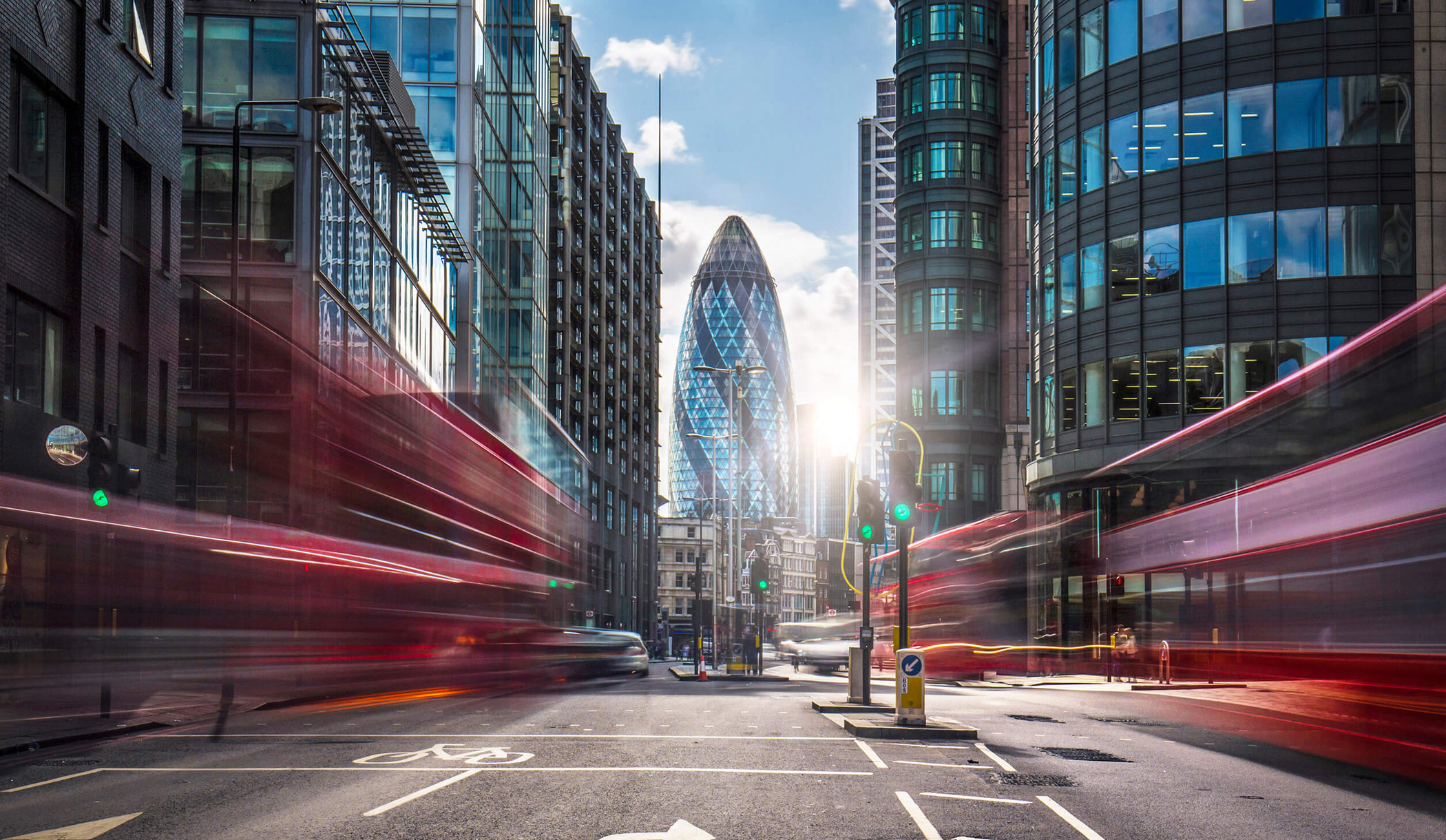 Vista de The Gherkin en Londres a través de dos casas por autobuses que pasan con movimiento borroso