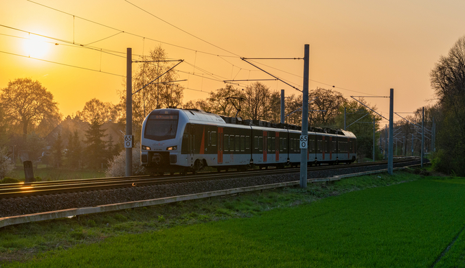 Tren sobre raíles ante una puesta de sol